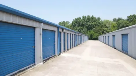 Row of outdoor drive-up storage units with metal roll-up doors