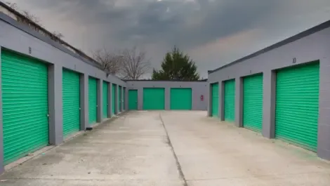 Several outdoor storage units with drive-up access and metal roll-up doors