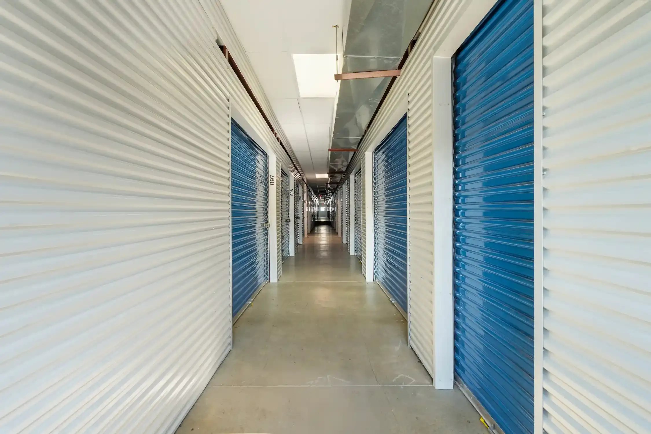 A hallway of units with blue doors.